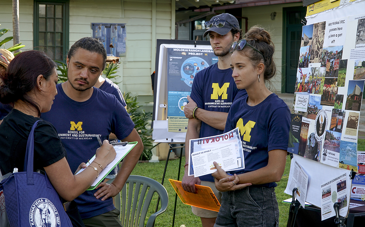 SEAS students interacting with a community member at a Sovereignty Restoration Day event.